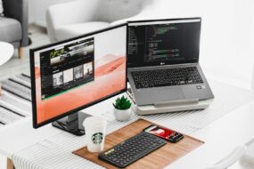 black flat screen computer monitor and laptop on table