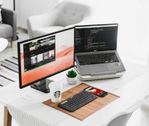 black flat screen computer monitor and laptop on table